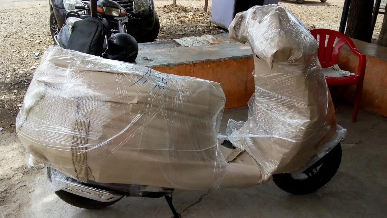 Scooter wrapped in protective sheet ready for loading
